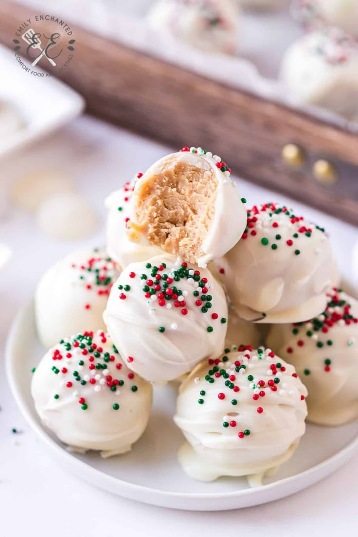 white chocolate covered donuts with sprinkles on a plate next to other dessert items