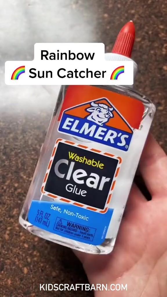 someone holding a bottle of clear glue in their hand with the caption rainbow sun catcher