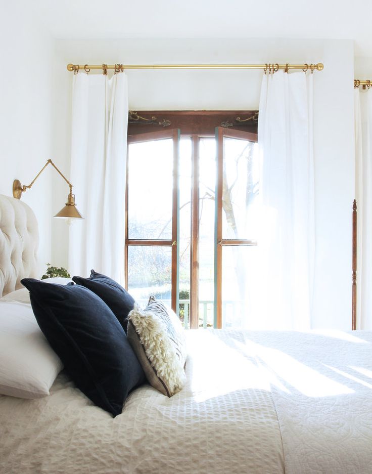 a bed with white sheets and black pillows