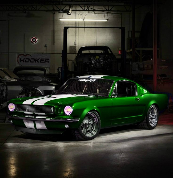 a green car parked in a garage next to other cars