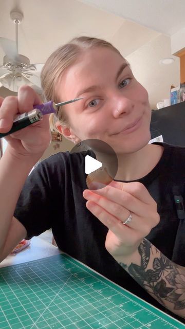 a woman is holding a spoon and looking at the camera while she's doing something