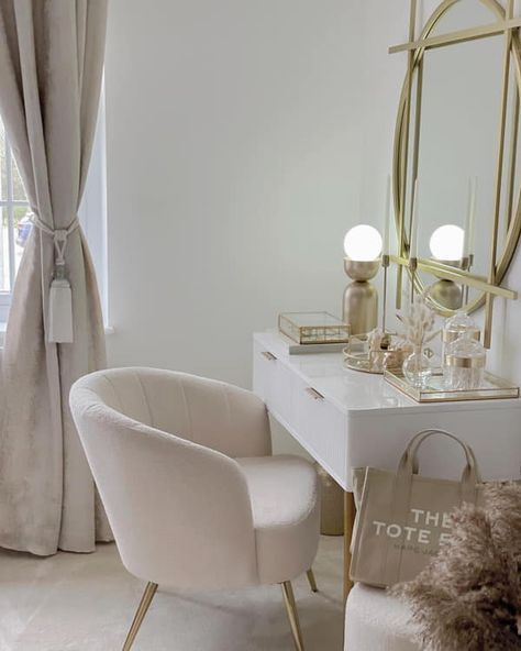 a white chair sitting in front of a mirror next to a desk with a bag on it