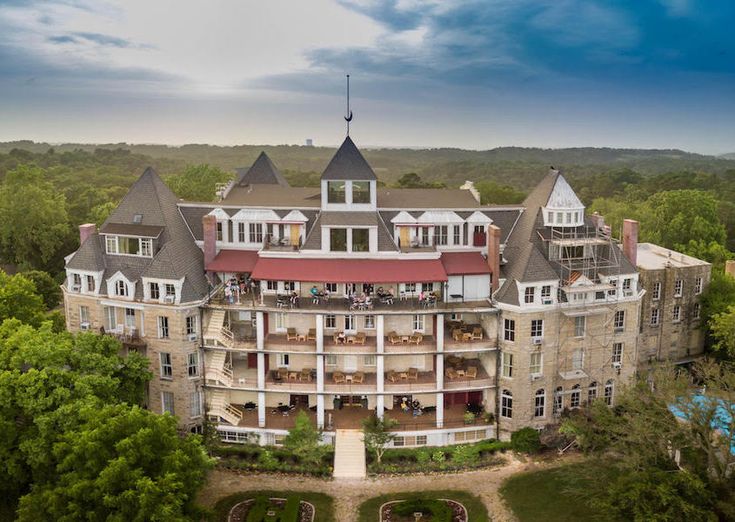 an aerial view of a large building in the middle of some trees and bushes with lots of windows