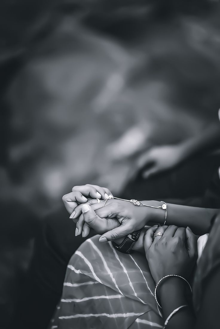 two people holding each other's hands in black and white