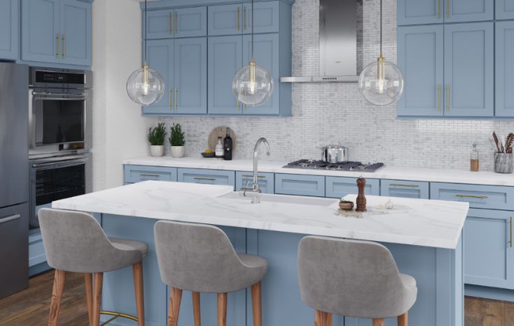 a kitchen with blue cabinets and marble counter tops, three bar stools in front of the island