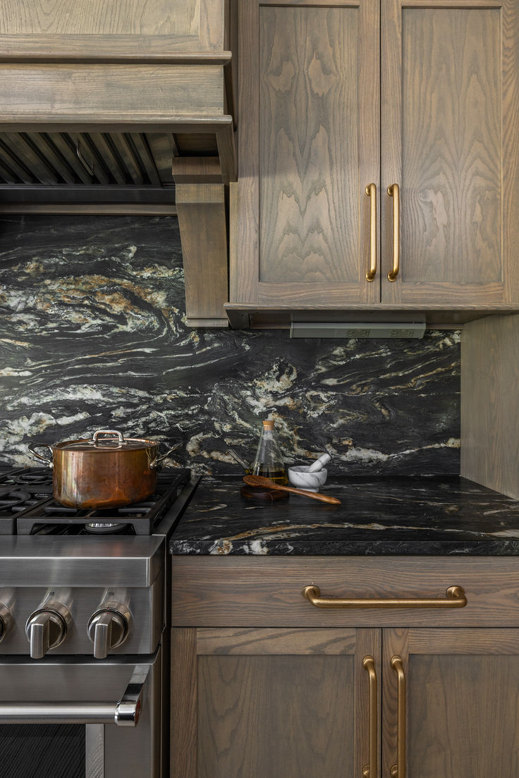 a stove top oven sitting inside of a kitchen next to wooden cabinets and counter tops