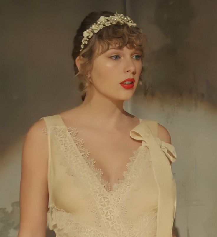 a woman wearing a white dress with a flower in her hair