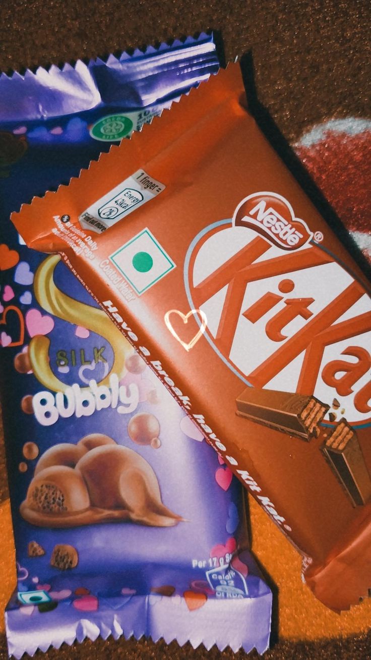 some kind of chocolate bar sitting on top of a carpet next to another bag of candy