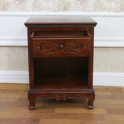 an old wooden table with a drawer on it's side in front of a wall