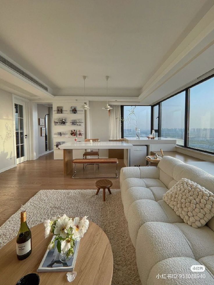 a living room filled with furniture and large windows