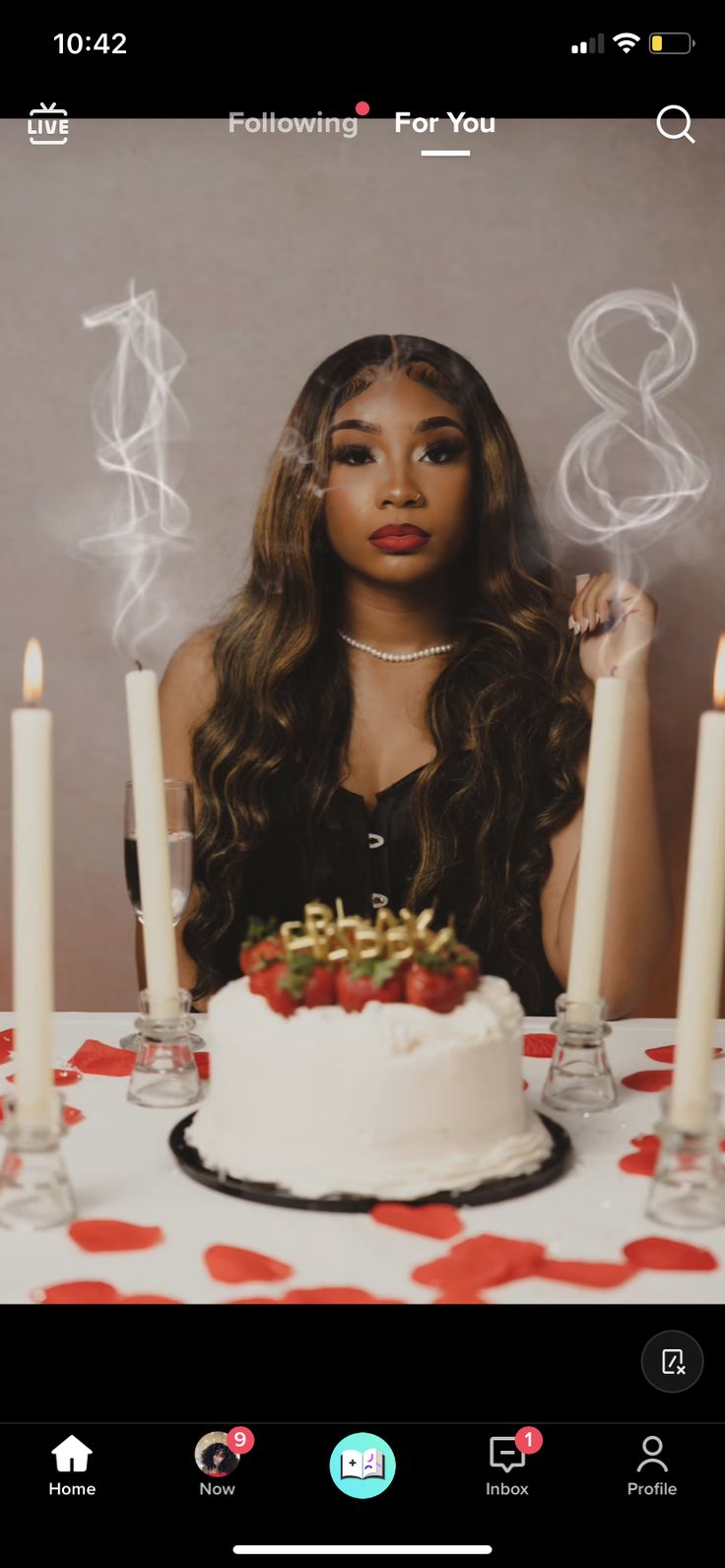 a woman sitting in front of a cake with candles