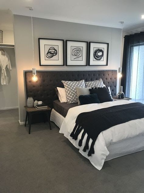 a bedroom with gray carpet, white bedding and two framed pictures on the wall