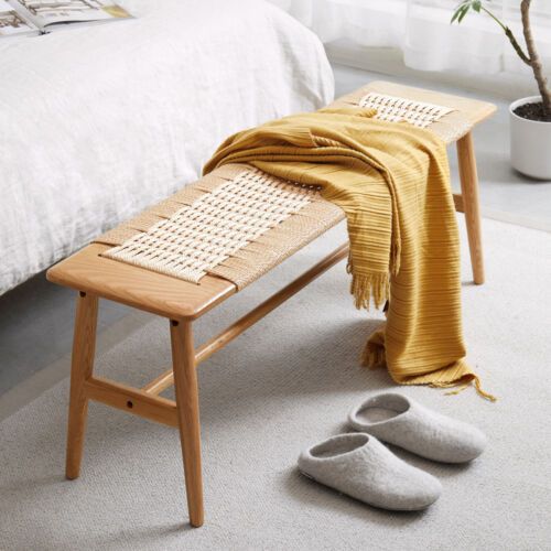 a pair of slippers sitting on top of a wooden bench next to a bed