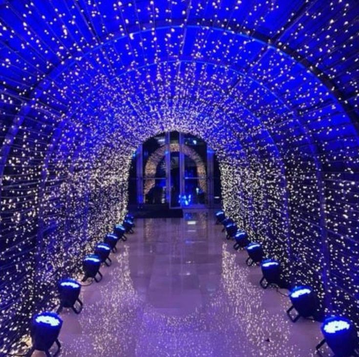 the inside of a tunnel covered in blue lights