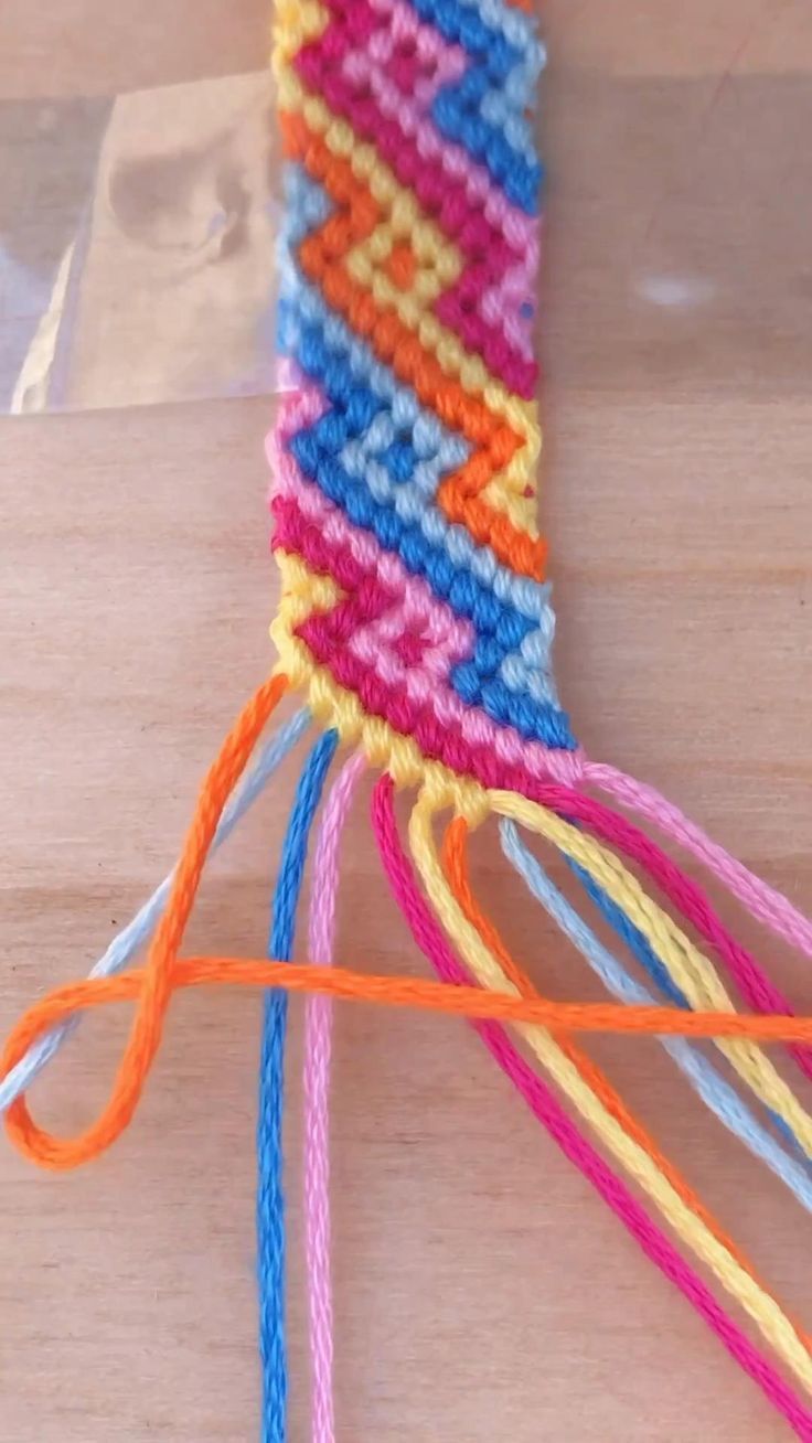 there are many different colors of yarn on the table with it's stringing