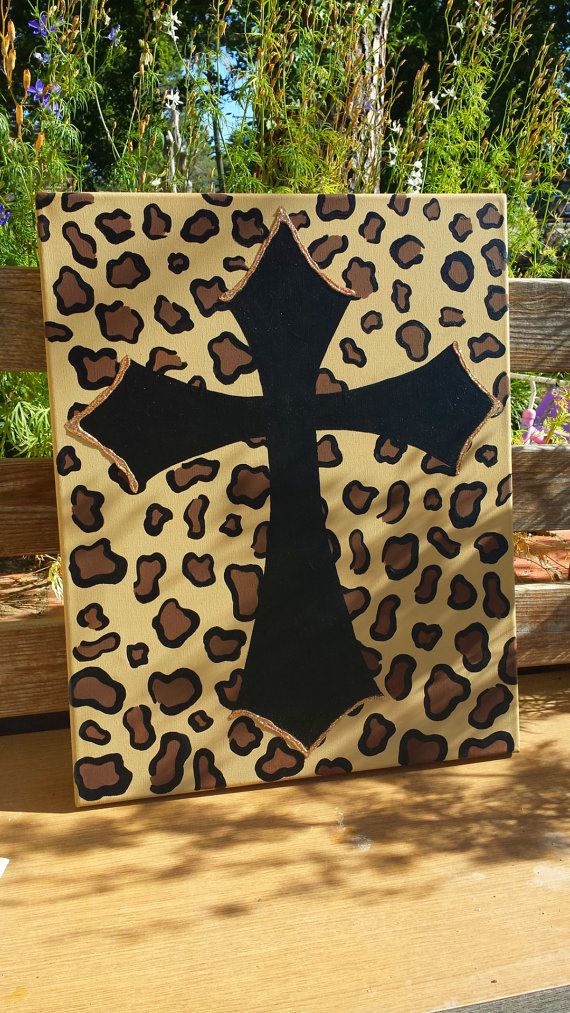 a cross painted on top of a leopard print canvas