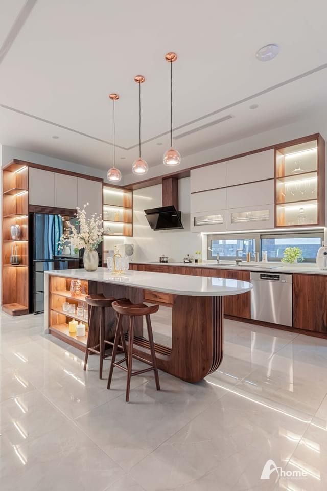 a large kitchen with an island and two stools in the middle of the room