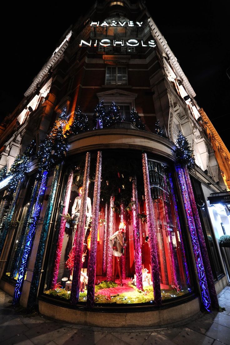 a very tall building with some lights on it's sides and decorations around the windows