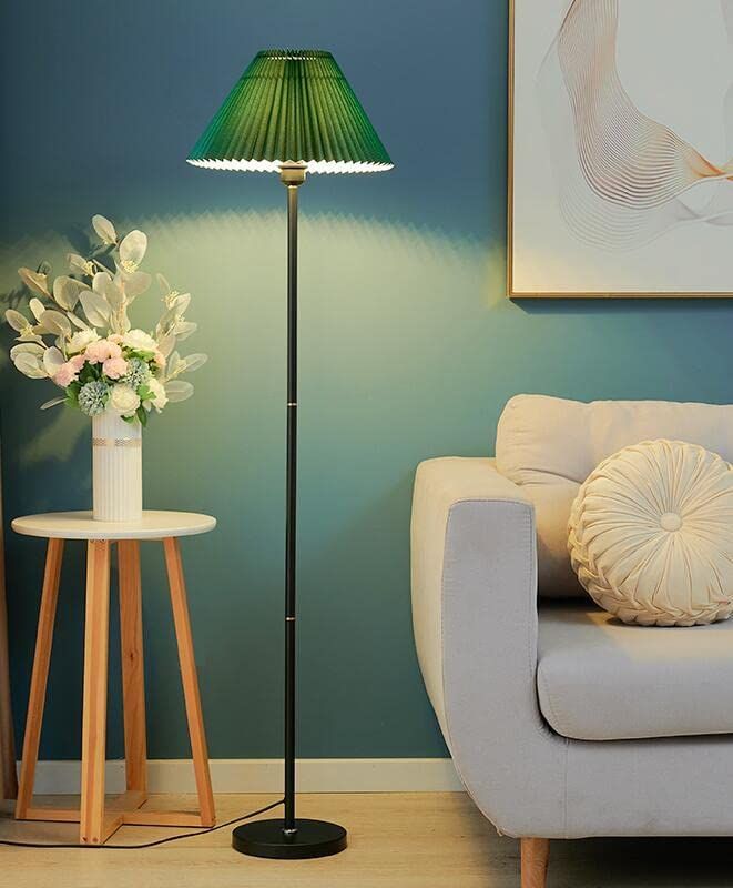 a living room scene with focus on the floor lamp and flowers sitting on the table