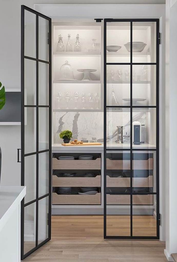 an open kitchen with glass doors leading to the dining room