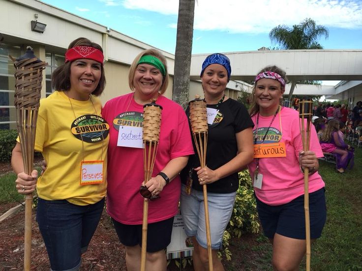 four women in pink and yellow shirts holding sticks