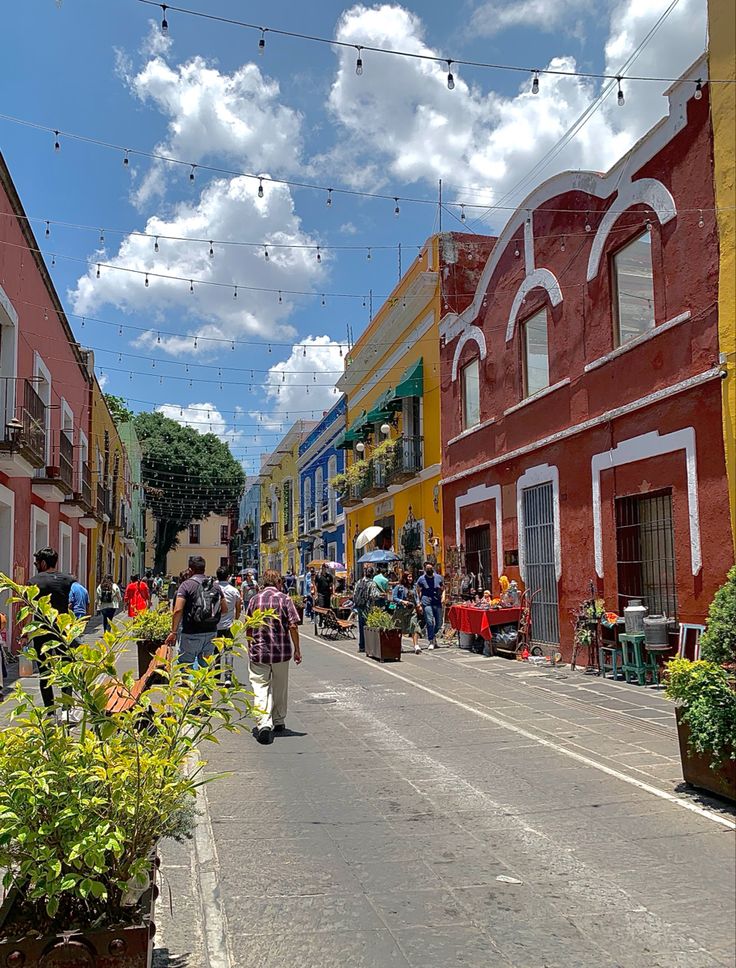 people walking down the street in front of colorful buildings