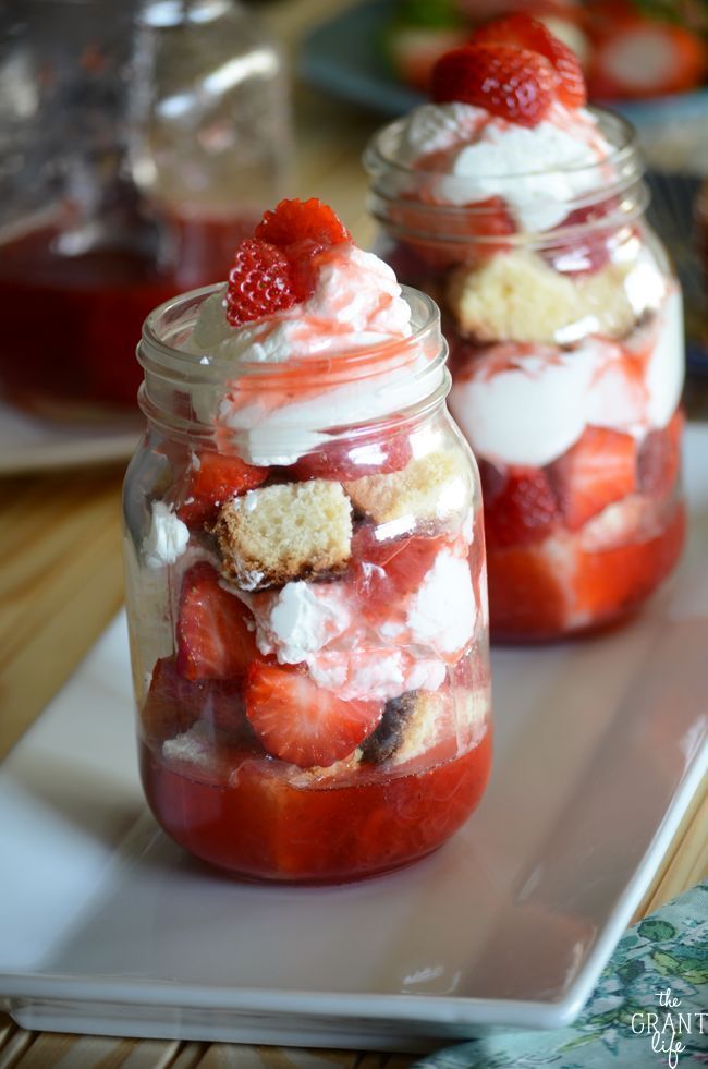 strawberry shortcakes in a mason jar with whipped cream and strawberries on top