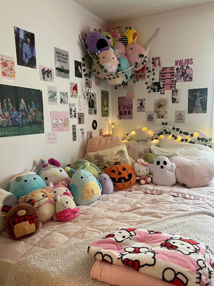 a bed with lots of stuffed animals on it and pictures hanging above the headboard