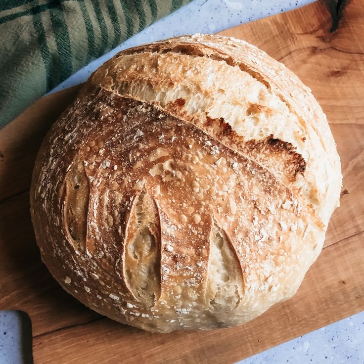 a loaf of bread sitting on top of a wooden cutting board