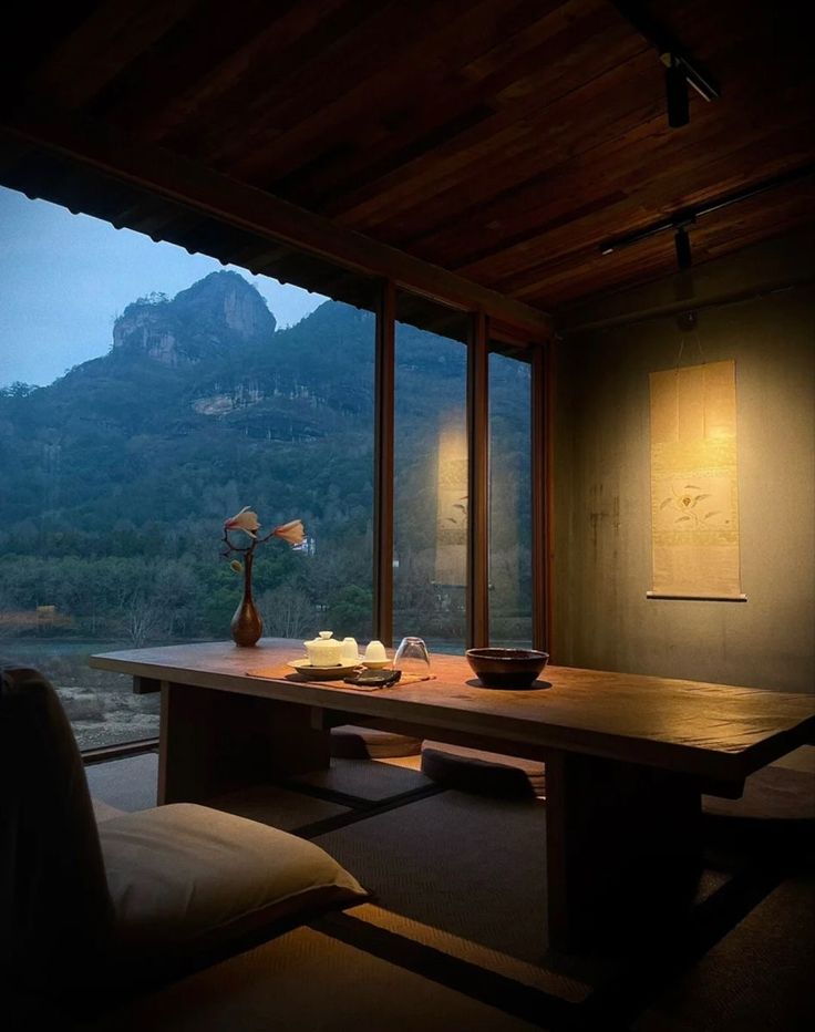 a room with a large table and some lights on the wall next to it, overlooking a mountain range