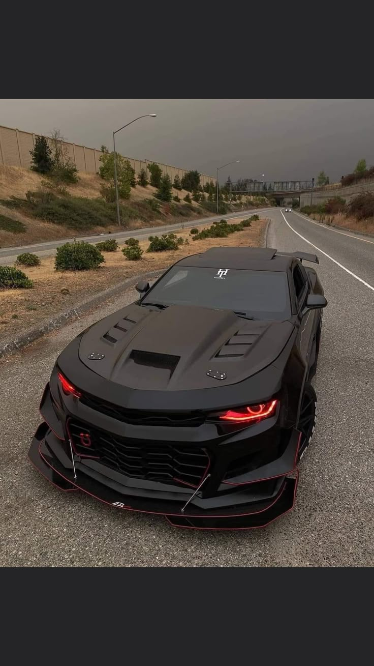 the black sports car is parked on the side of the road