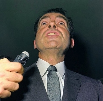 a man in a suit and tie holding a cell phone