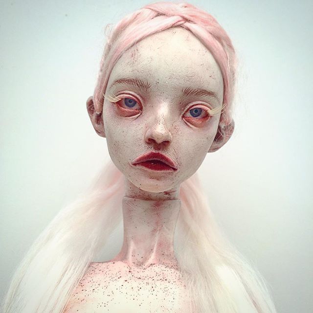 a woman with pink hair and white skin has freckles on her face as if she is an alien