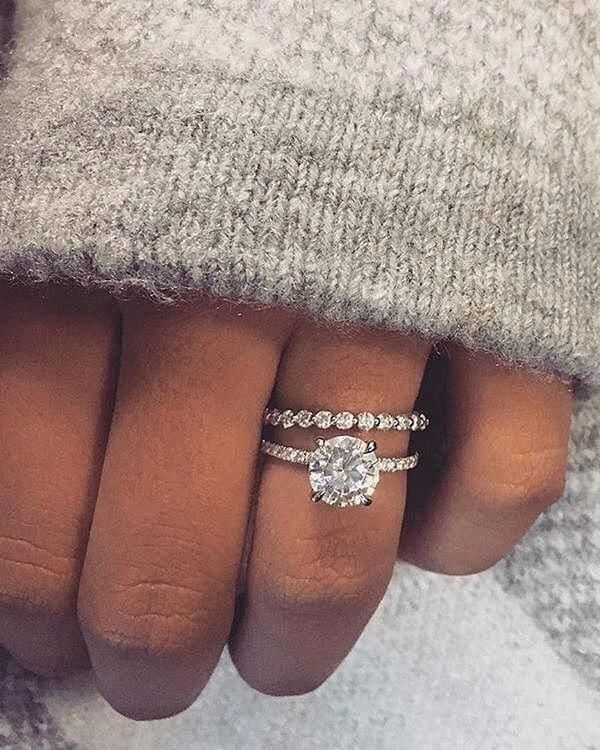 a woman's hand with a ring on it and a diamond in the middle