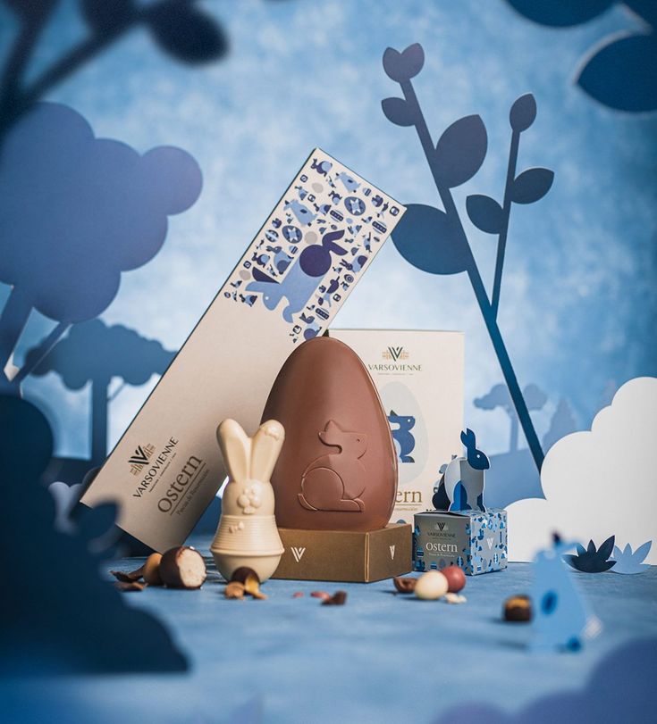 an easter egg and bunny figurine on a blue background with clouds in the sky