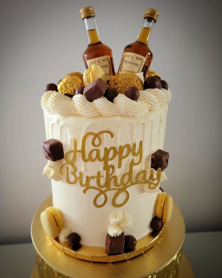 a birthday cake with two bottles of liquor on top and chocolate chips around the edges