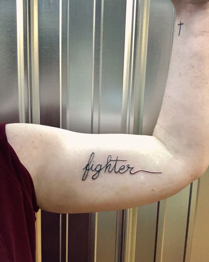 a man's arm with the word fighter tattooed on it in cursive font