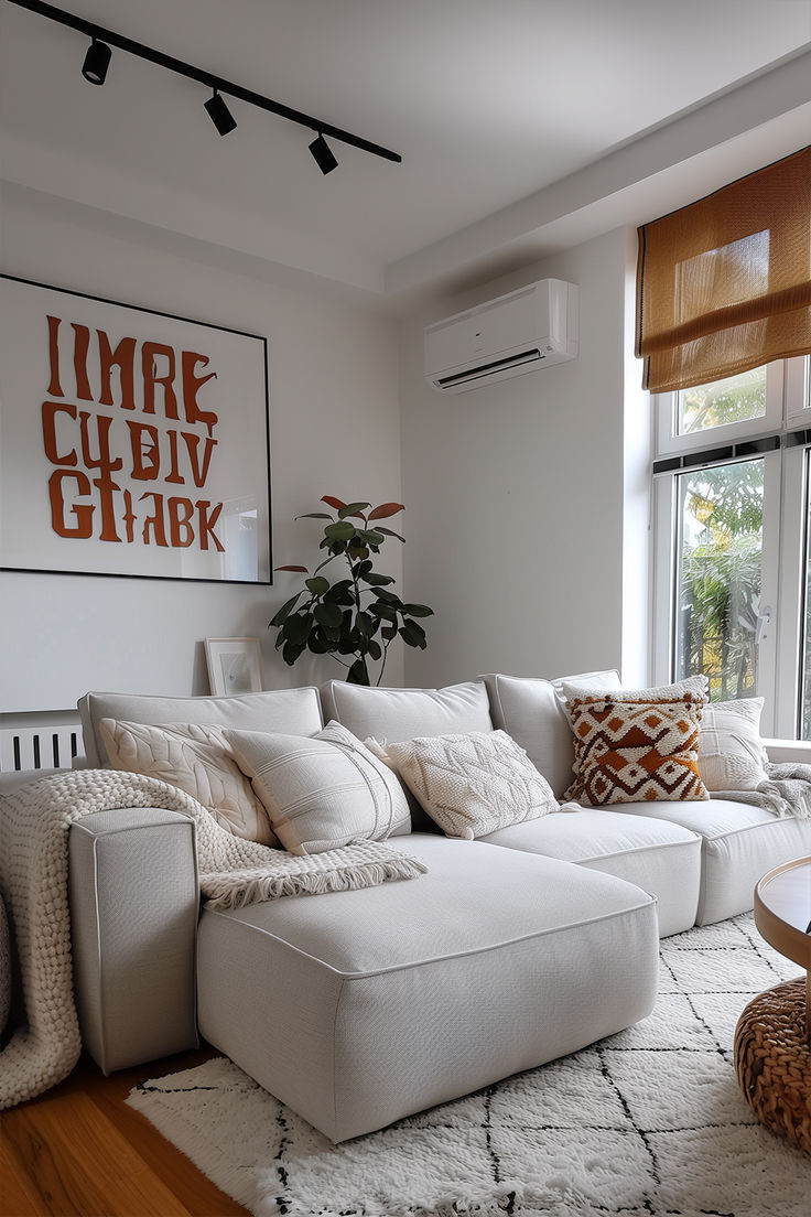 a living room filled with white furniture next to a large window on top of a hard wood floor