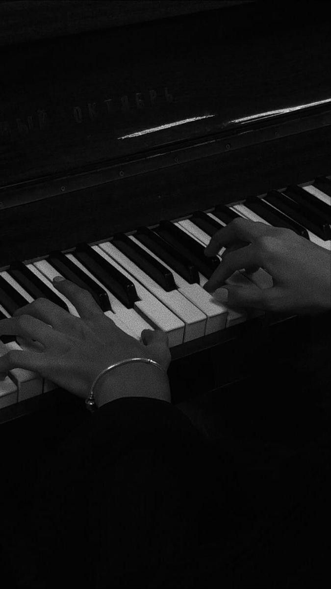 two hands playing the piano in black and white