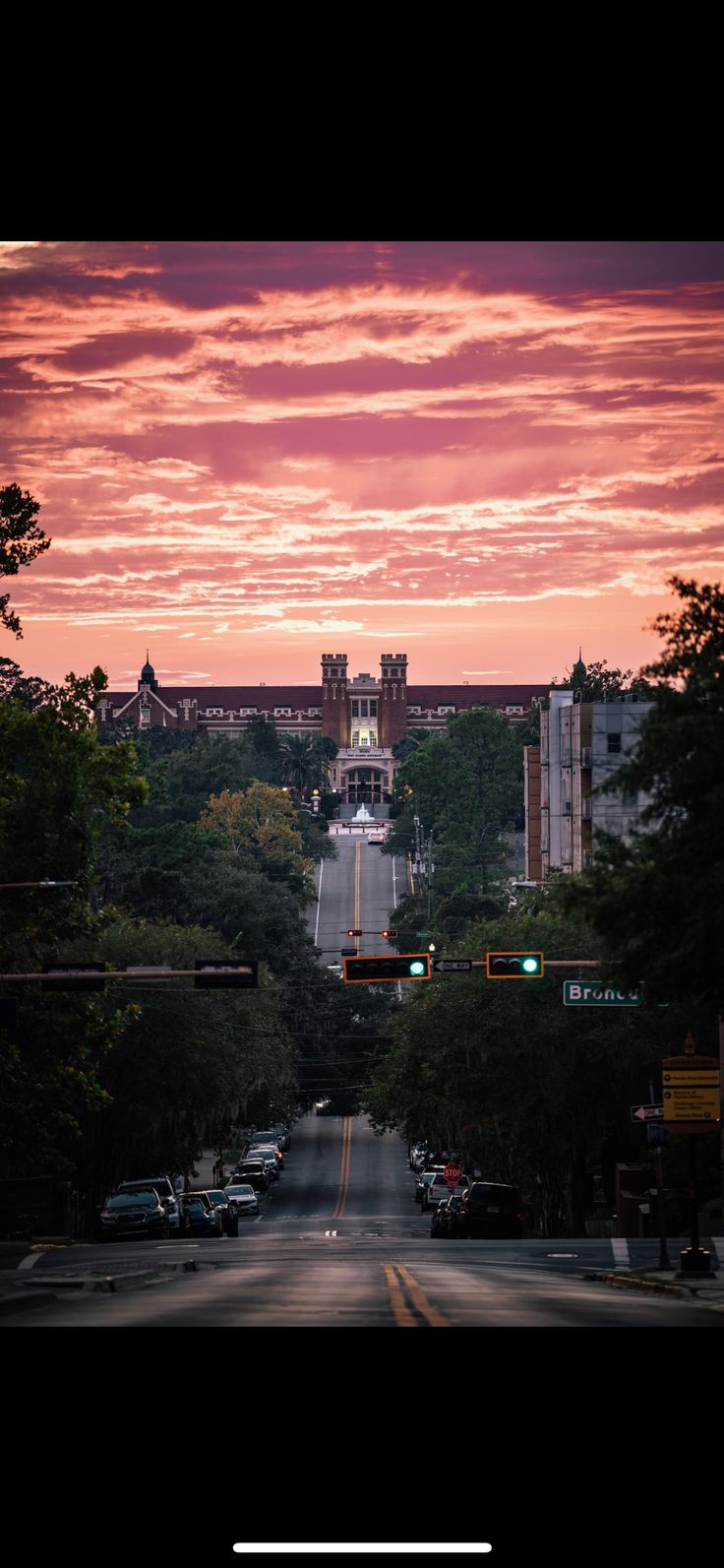 the sun is setting over a city street