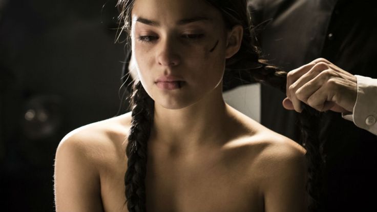 a woman is getting her hair braided