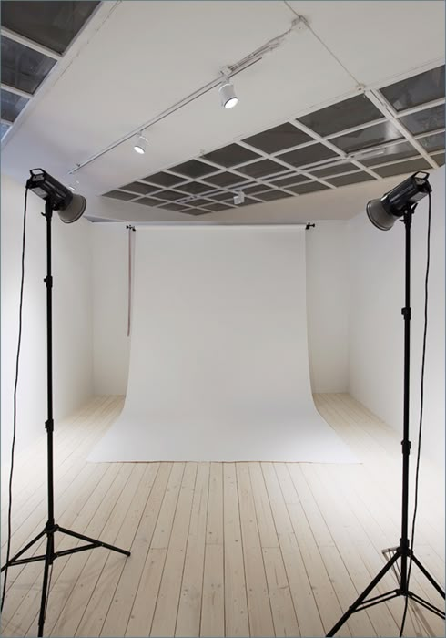 an empty photo studio with two light stands