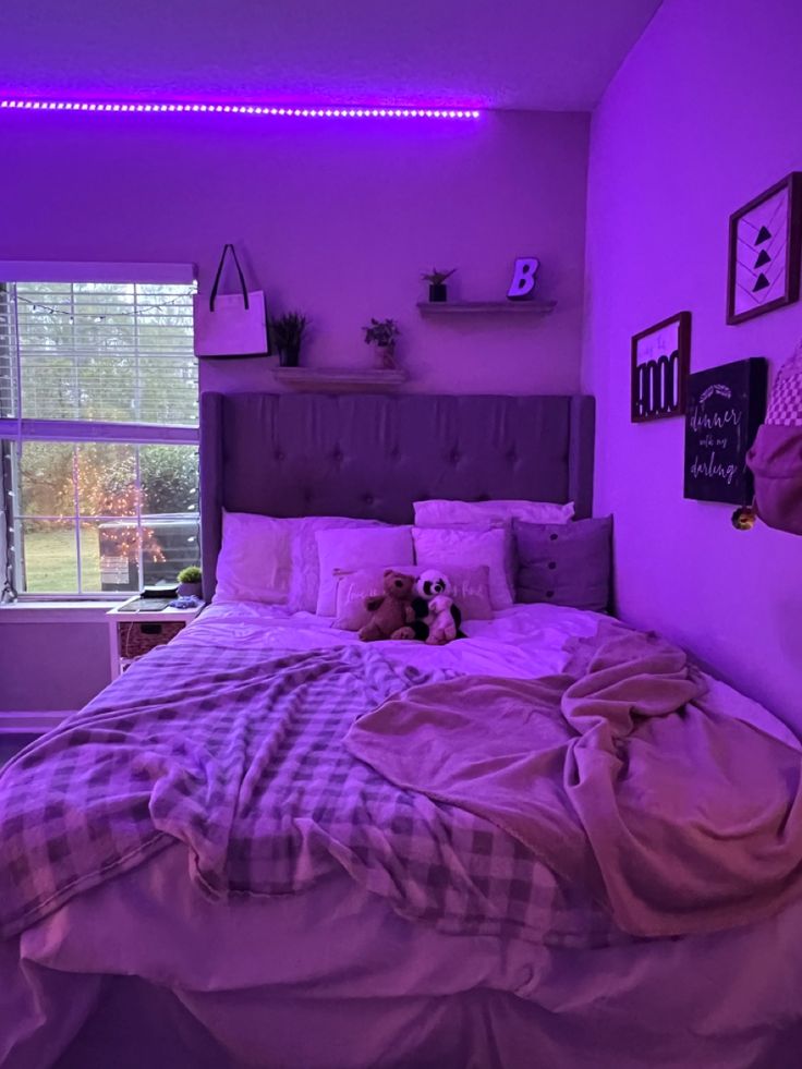 a bedroom with purple lighting and a dog laying on the bed