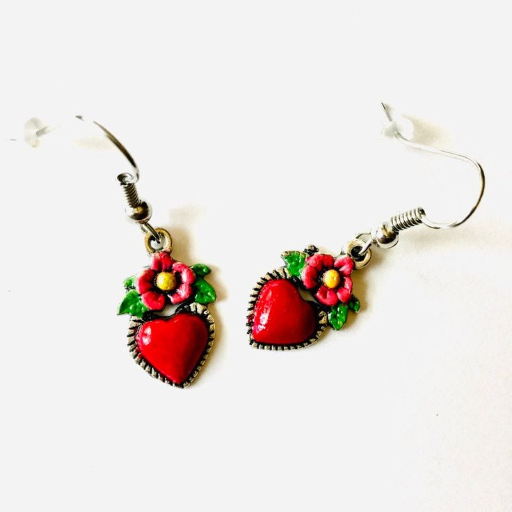 Embrace the adventurous spirit of Frida Kahlo with these intricately hand-painted heart earrings. Every pair is carefully crafted in our studio, paying close attention to even the smallest details and finished with a striking coat of enamel. These tiny-yet-gorgeous earrings are a one-of-a-kind and budget-friendly present, ideal for yourself or someone special. Don't hesitate to claim these captivating Frida-inspired earrings for yourself! These heart-shaped dangling earrings are not only a uniqu Heart-shaped Enamel Earrings With Charm, Heart Charm Enamel Earrings, Hand Painted Enamel Jewelry For Gifts, Hand Painted Enamel Jewelry Gift, Handmade Heart-shaped Enamel Earrings, Valentine's Day Heart Charm Enamel Earrings, Handmade Heart-shaped Enamel Jewelry, Enamel Heart Charm Earrings As Gift, Enamel Earrings With Heart Charm As Gift