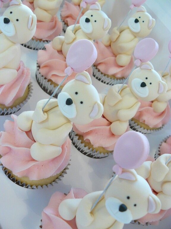 cupcakes decorated with teddy bears and pink icing on a white platter