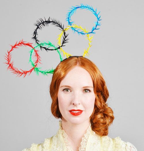 a woman with red hair wearing a white shirt and colorful headbands on her head