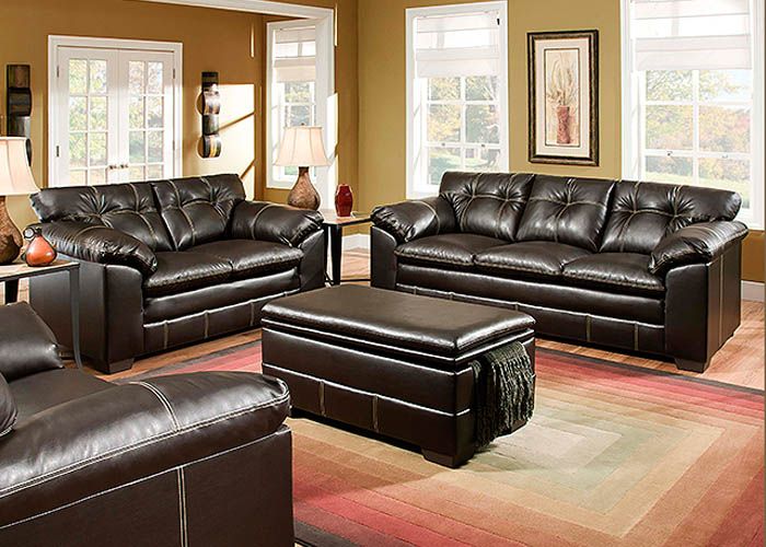 a living room filled with brown furniture and lots of windows