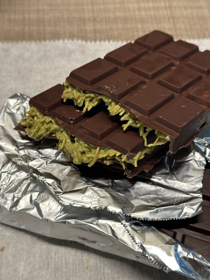 there is a piece of chocolate that has been cut in half and placed on top of aluminum foil