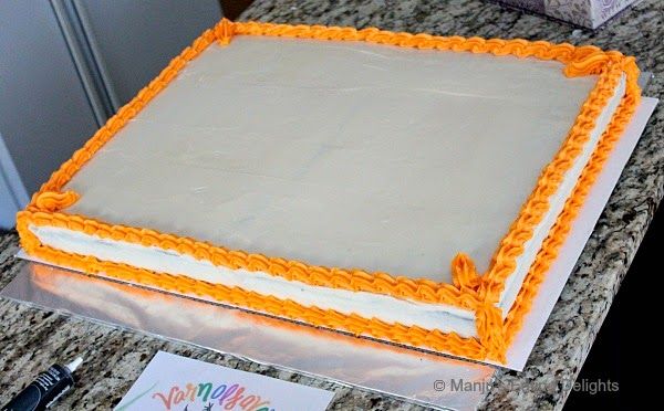 an orange and white birthday cake sitting on top of a counter next to a sign