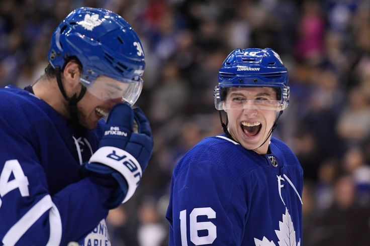 two canadian hockey players are laughing at each other's faces in front of an audience